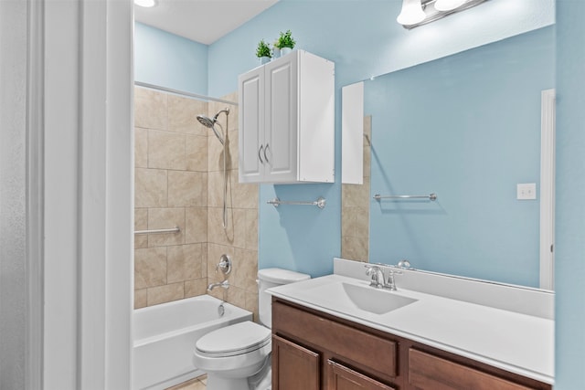 full bathroom featuring vanity, tiled shower / bath combo, and toilet