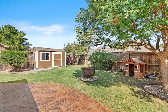 view of yard with a shed, a fire pit, and a patio