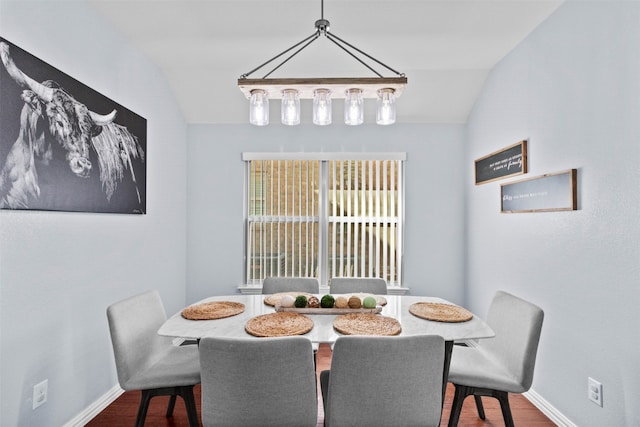 dining room featuring wood-type flooring and vaulted ceiling