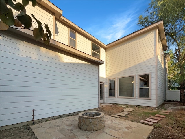 rear view of house featuring an outdoor fire pit and a patio area