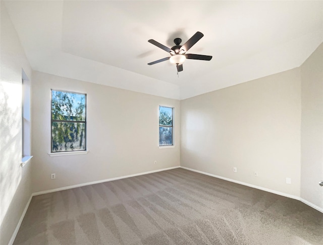 empty room with carpet floors, ceiling fan, and a wealth of natural light