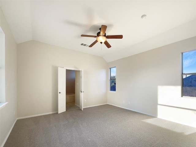 carpeted spare room featuring ceiling fan and vaulted ceiling