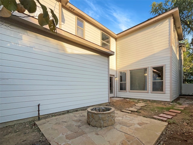 rear view of property with a patio and a fire pit