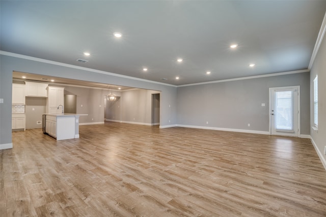 unfurnished living room featuring ornamental molding and light hardwood / wood-style flooring