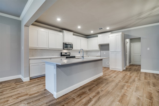 kitchen with crown molding, white cabinetry, stainless steel appliances, and light wood-type flooring