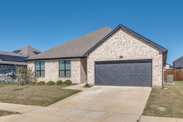 view of front of home featuring a front lawn, central AC unit, and a garage