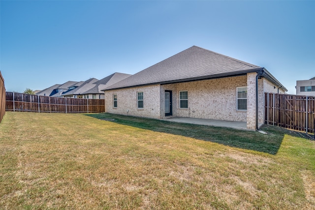 rear view of house featuring a yard and a patio area