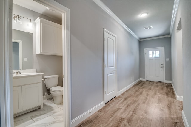 doorway featuring light hardwood / wood-style flooring, crown molding, and sink