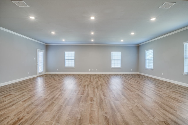 spare room with light hardwood / wood-style flooring and crown molding