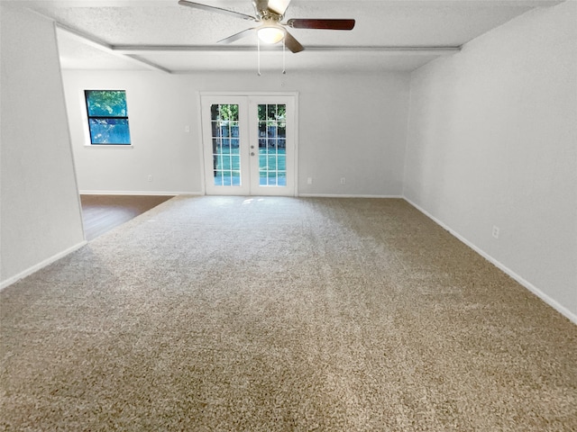 carpeted empty room featuring french doors, ceiling fan, and a textured ceiling