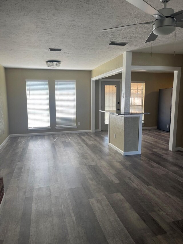 1326 Greenbriar Ln, Lancaster, TX 75146 - unfurnished living room with dark wood-style floors, a ceiling fan, baseboards, and a textured ceiling