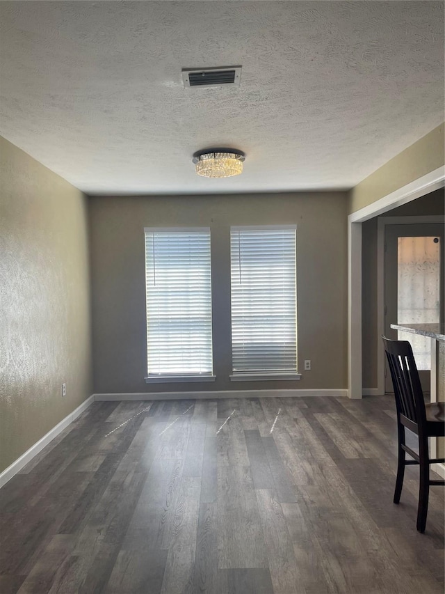 1326 Greenbriar Ln, Lancaster, TX 75146 - unfurnished room with dark wood finished floors, baseboards, and a textured ceiling