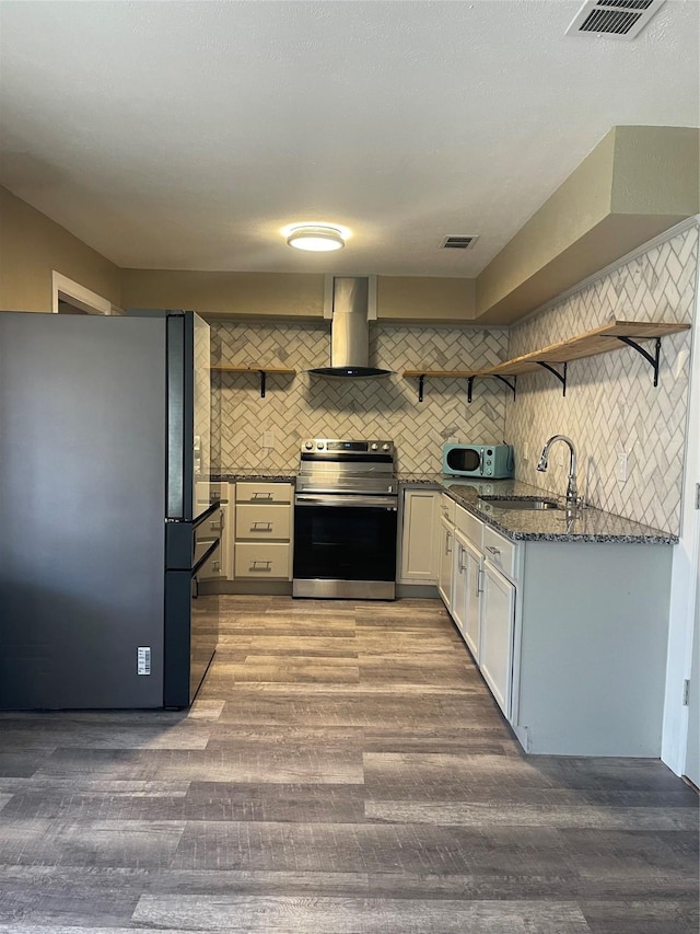 1326 Greenbriar Ln, Lancaster, TX 75146 - kitchen featuring stainless steel electric stove, freestanding refrigerator, open shelves, wall chimney range hood, and a sink