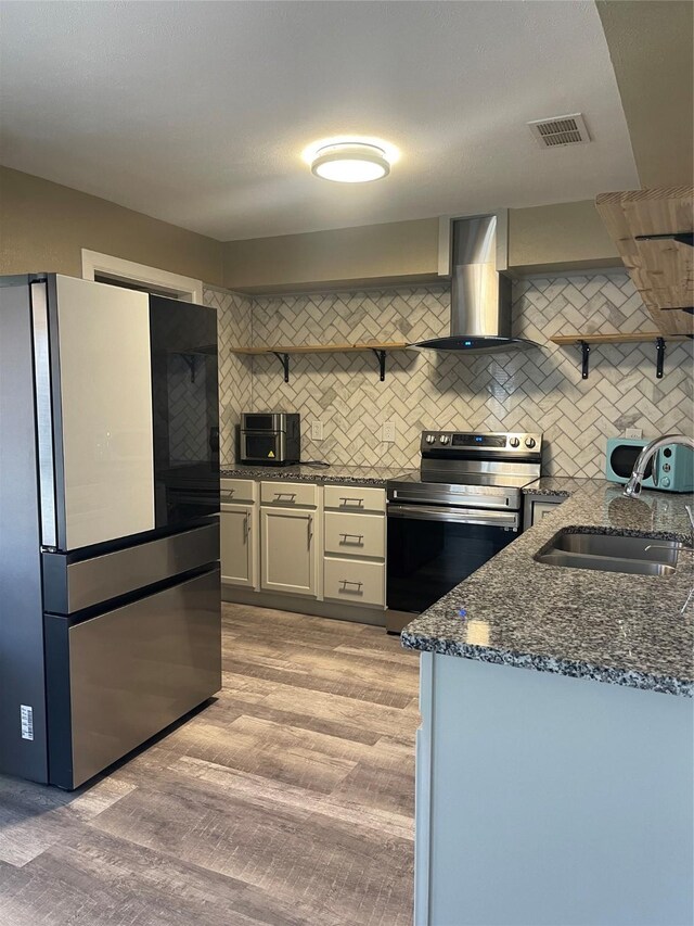 1326 Greenbriar Ln, Lancaster, TX 75146 - kitchen with open shelves, stainless steel appliances, a sink, and wall chimney range hood