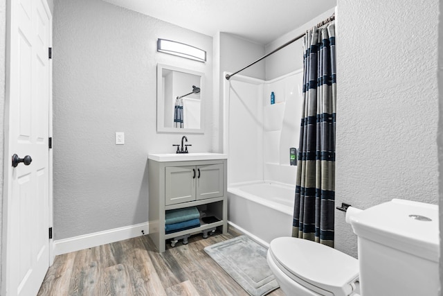 bathroom featuring a textured wall, wood finished floors, toilet, baseboards, and shower / bathtub combination with curtain