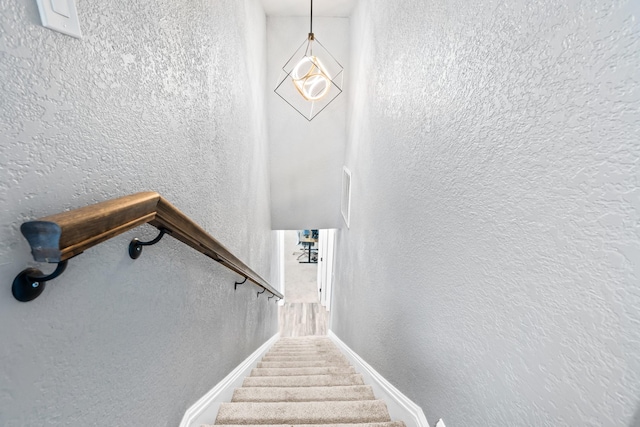staircase with baseboards and a textured wall