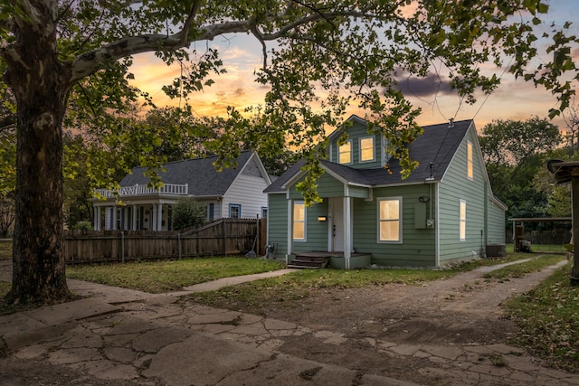 view of front of home with central air condition unit, fence, and dirt driveway