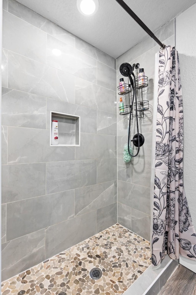 bathroom featuring a textured ceiling and a shower stall