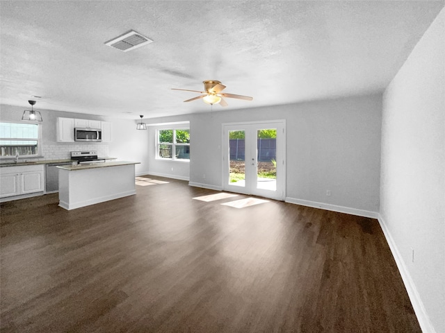 unfurnished living room featuring ceiling fan, a textured ceiling, sink, and dark hardwood / wood-style floors