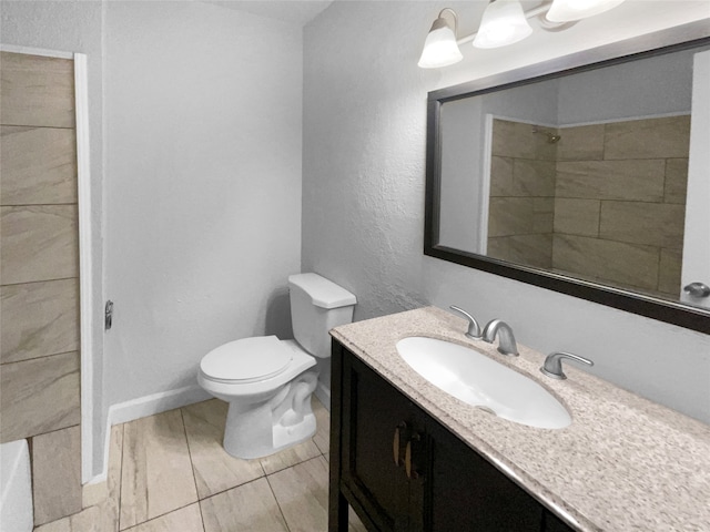 bathroom with vanity, toilet, tiled shower, and tile patterned flooring