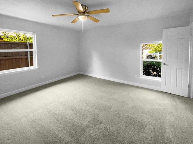 empty room featuring carpet, a healthy amount of sunlight, and ceiling fan