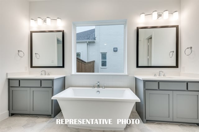 bathroom with a bathing tub, vanity, and tile patterned flooring