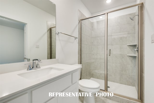 bathroom featuring a shower with door, vanity, and toilet