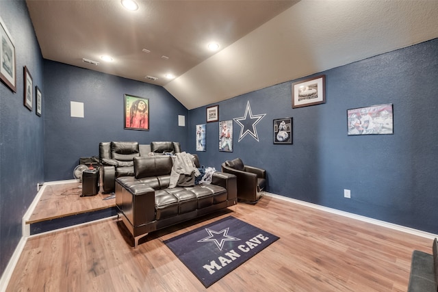 cinema featuring vaulted ceiling and wood-type flooring