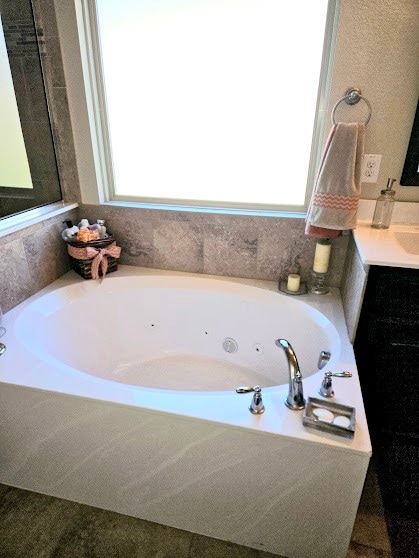 bathroom with vanity and a bath