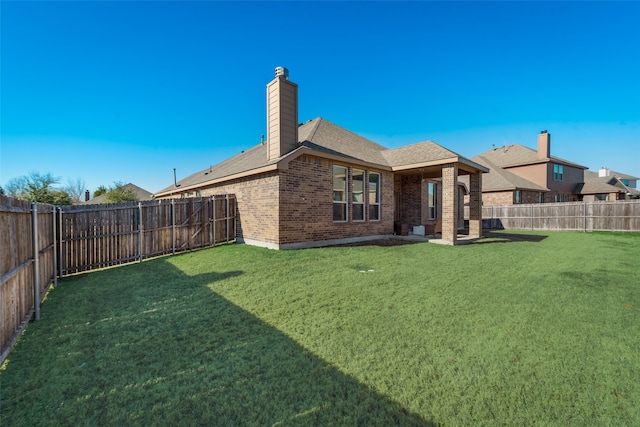 rear view of property with a yard and a patio