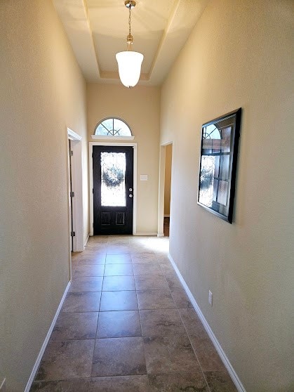 doorway to outside with a tray ceiling