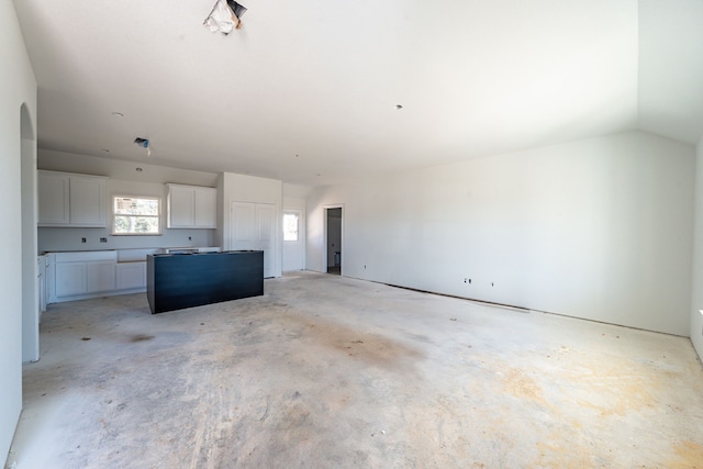 unfurnished living room with lofted ceiling