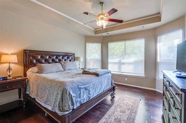 bedroom featuring ceiling fan, a raised ceiling, dark hardwood / wood-style flooring, and crown molding