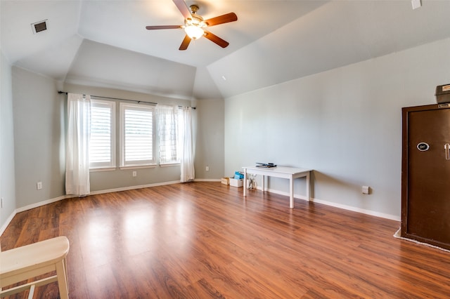 empty room with ceiling fan, wood-type flooring, and vaulted ceiling