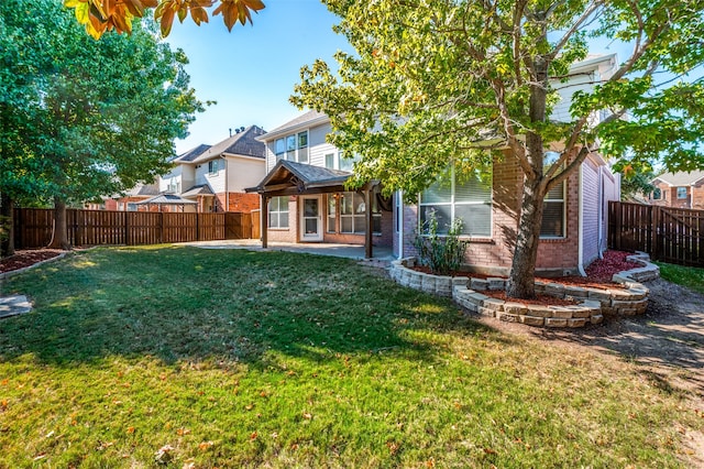 rear view of property with a yard and a patio area