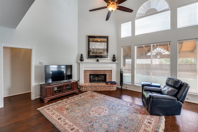 living room with a high ceiling, plenty of natural light, and dark hardwood / wood-style floors