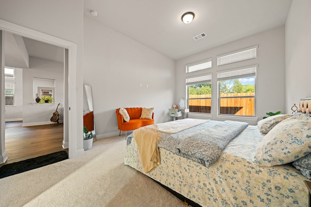 carpeted bedroom with lofted ceiling