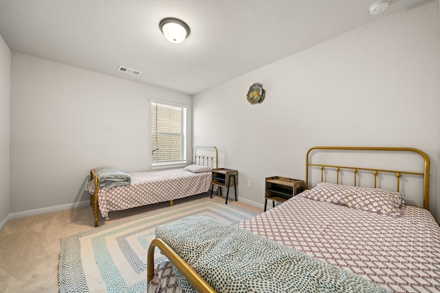 bedroom featuring light carpet and a textured ceiling