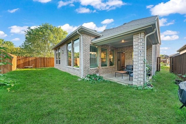 back of house with a patio and a yard