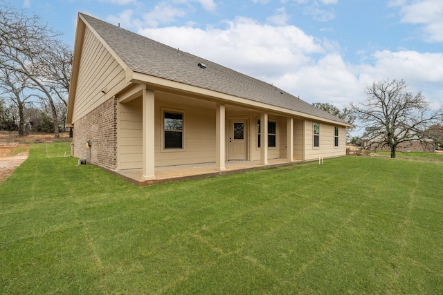 rear view of house featuring a patio area and a lawn