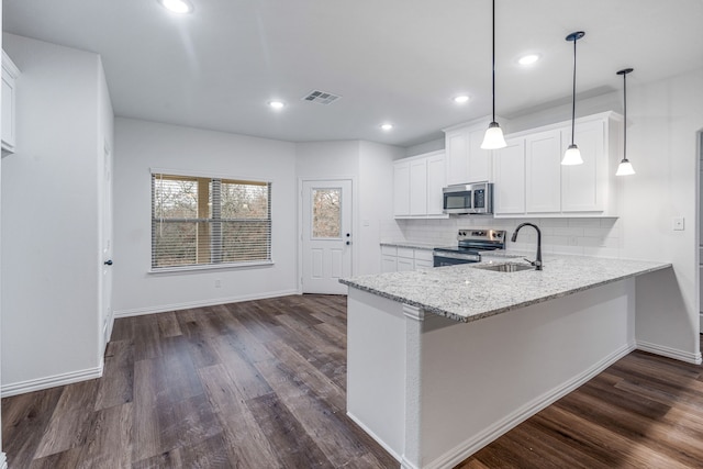 kitchen featuring appliances with stainless steel finishes, sink, white cabinets, hanging light fixtures, and light stone countertops