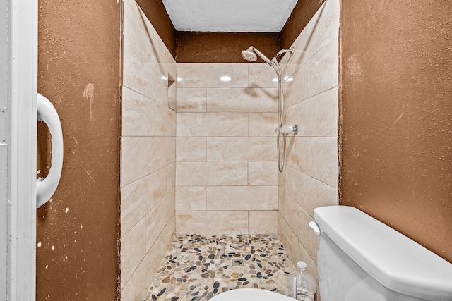 bathroom featuring toilet and tiled shower