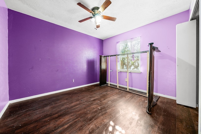 unfurnished bedroom featuring dark hardwood / wood-style flooring, a textured ceiling, and ceiling fan