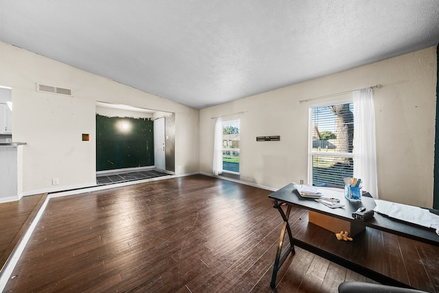 home office with hardwood / wood-style floors, vaulted ceiling, and a textured ceiling