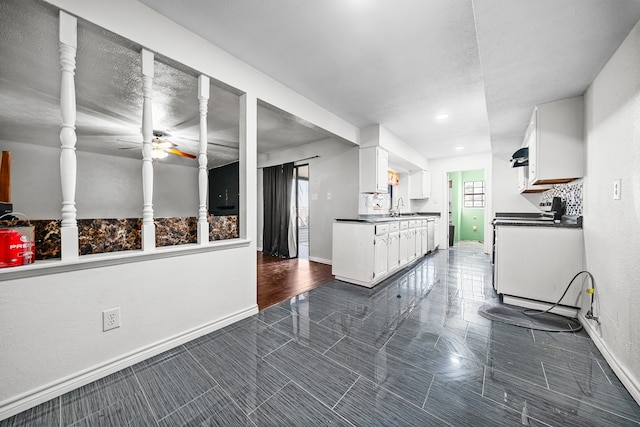 interior space with white cabinetry, sink, and ceiling fan