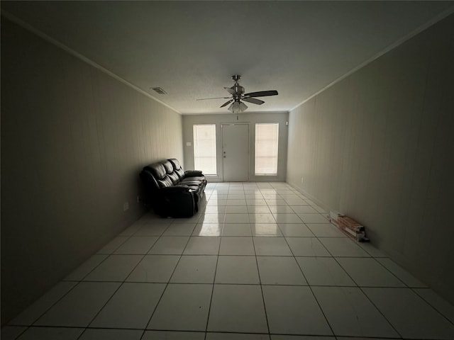 interior space with ceiling fan, crown molding, and light tile patterned floors