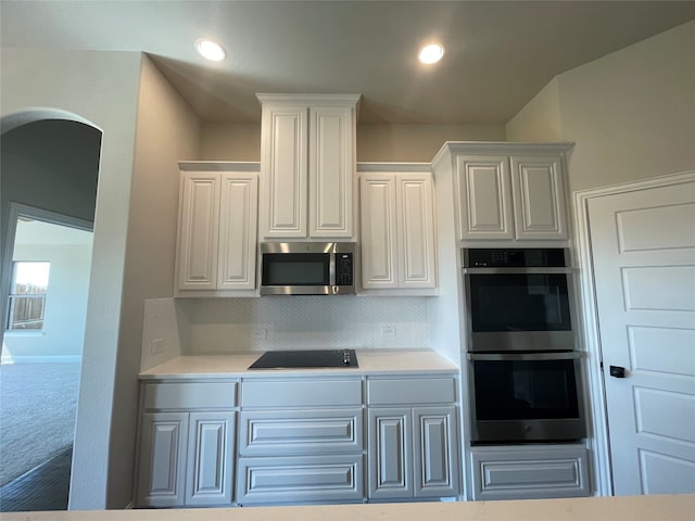 kitchen featuring appliances with stainless steel finishes, white cabinets, and backsplash