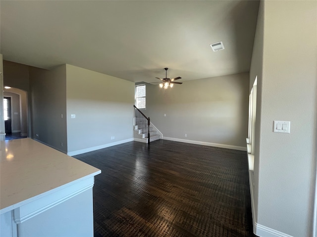 unfurnished living room featuring ceiling fan and dark hardwood / wood-style flooring