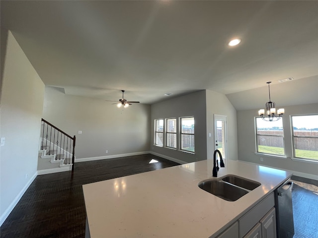 kitchen with decorative light fixtures, sink, a center island with sink, and vaulted ceiling