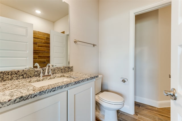 bathroom with vanity, wood-type flooring, and toilet